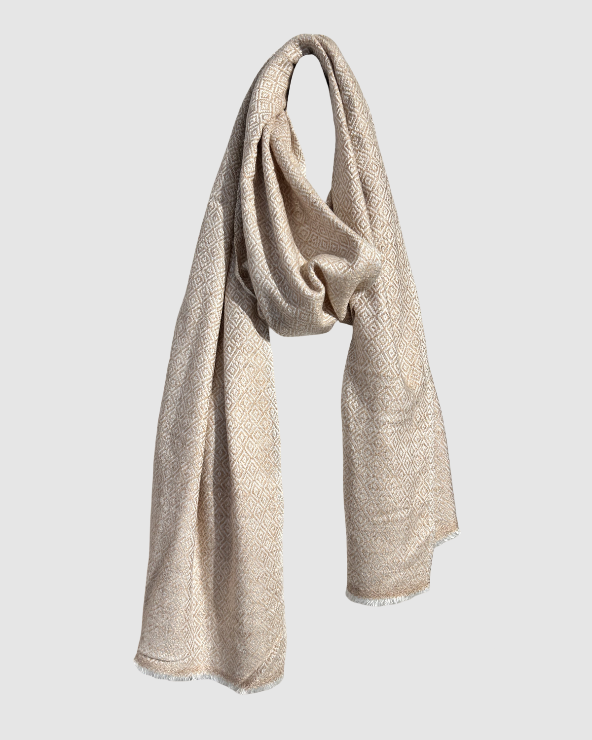 Håndvævet tørklæde i blød merinould i farven lys sand, produceret bæredygtigt på et fair trade kooperativ i Nepal.