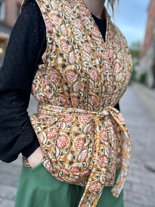 Vendbar quiltet vest i 100% bomuld - Sennepsgul blomstret