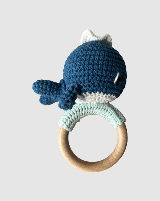 Håndhæklet blå hval rangle i økologisk bomuld til baby, produceret med fokus på social ansvarlighed.