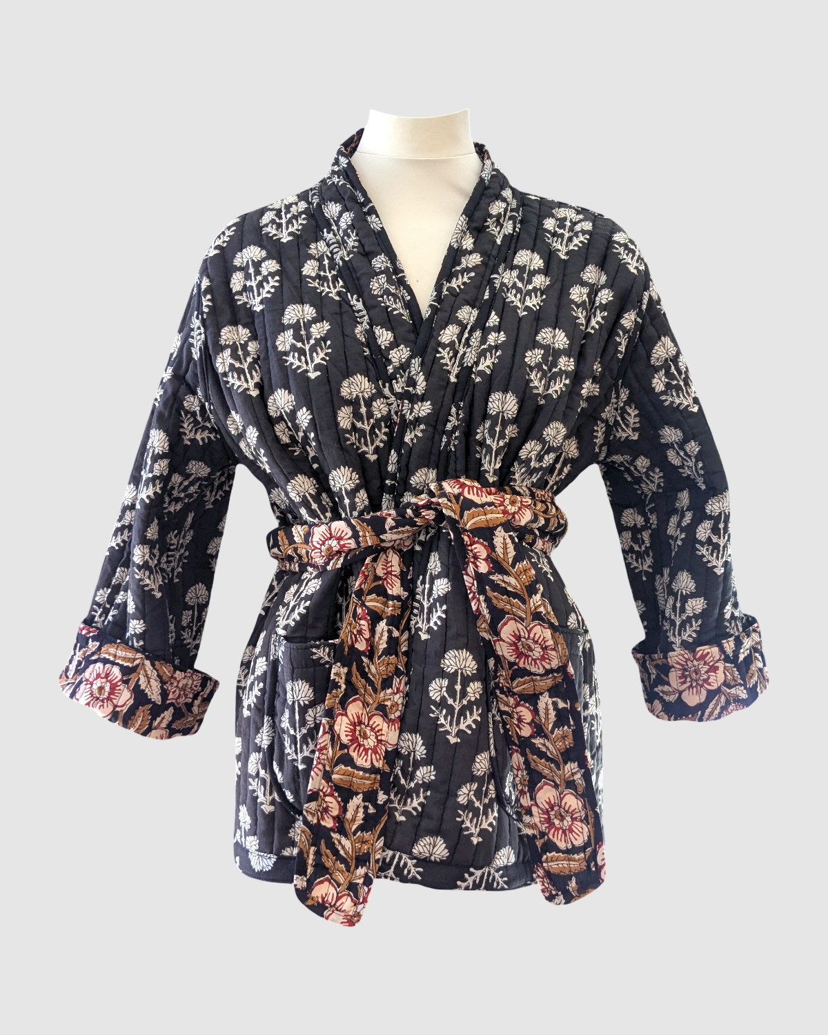 Vendbar jakke i 100% bomuld – sort med brunde blomster og sort med hvide blade