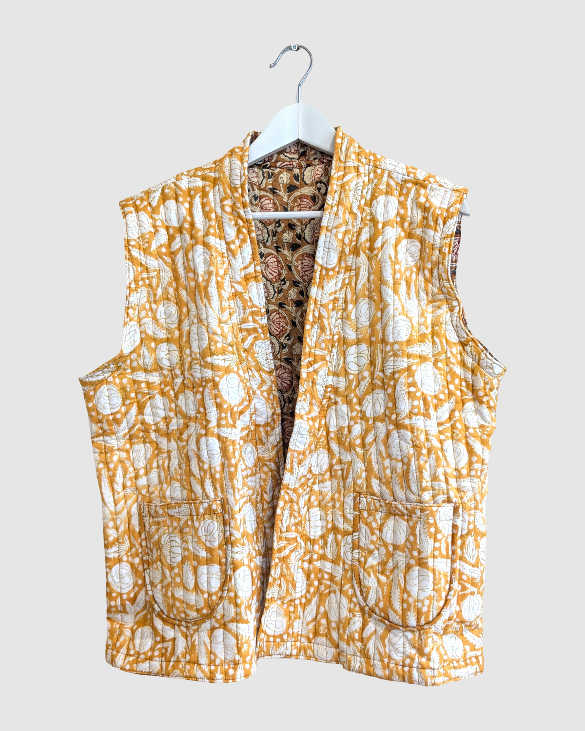 Vendbar quiltet vest i 100% bomuld - Sennepsgul blomstret